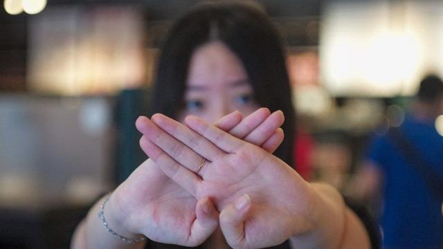 Taiwanese woman with crossed hands in front of her face